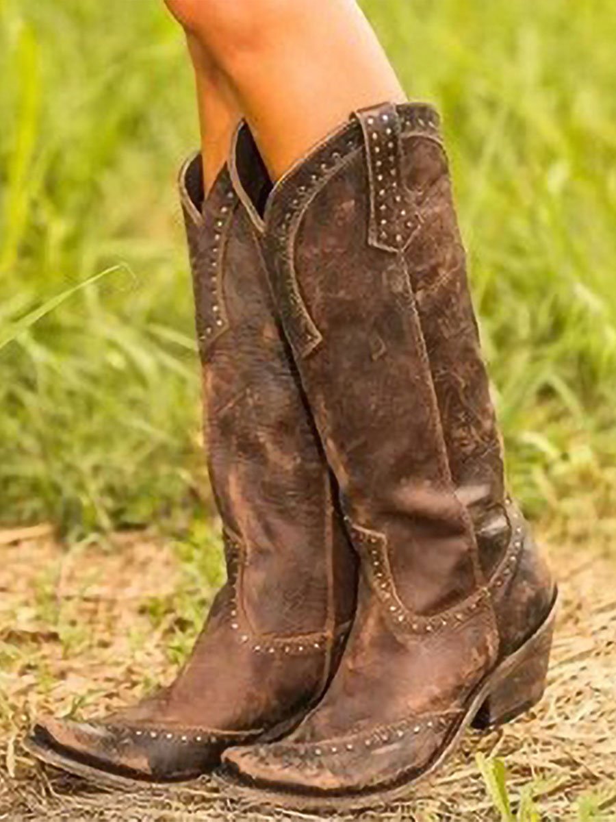 Tall studded Western cowboy boots with pointed toes and low heels