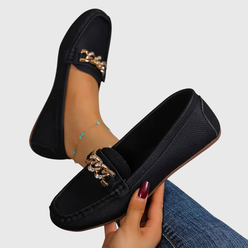 Women's flat slip-on loafers with moc toe stitching and decorative chain detail