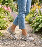 Women's textured slip-on loafers with decorative metal-tone buckles and ridged soles