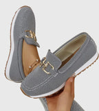 Women's textured slip-on loafers with decorative metal-tone buckles and ridged soles