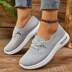 Women's light grey slip-on trainers with lace detail and white textured soles