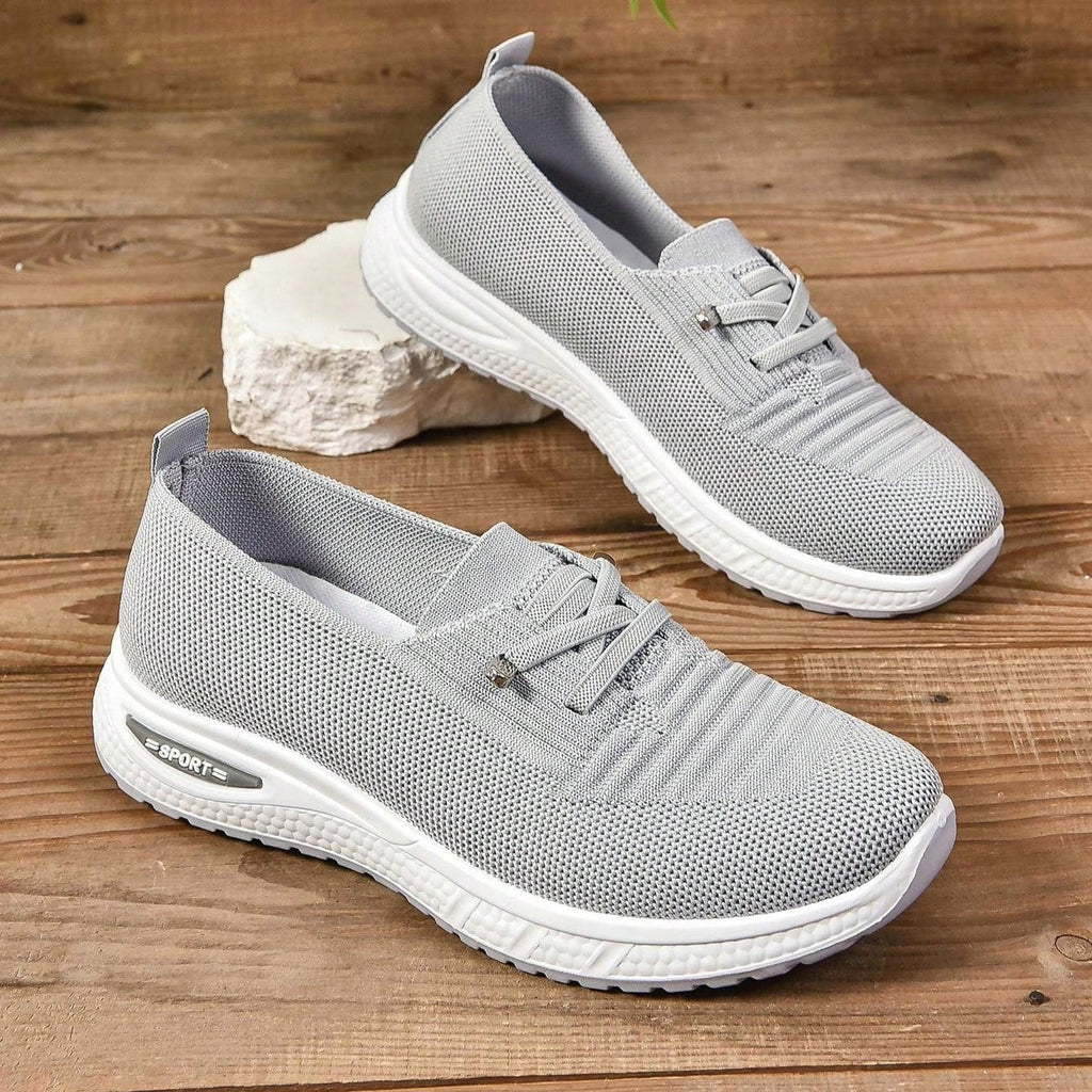 Women's light grey slip-on trainers with lace detail and white textured soles