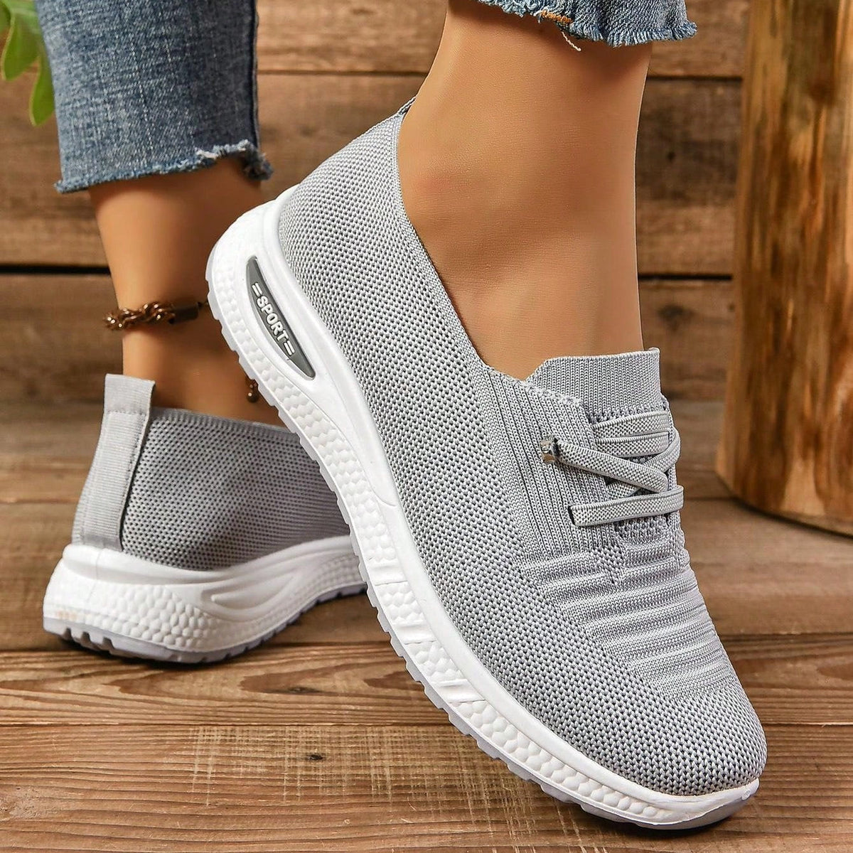 Women's light grey slip-on trainers with lace detail and white textured soles