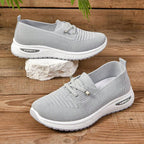 Women's light grey slip-on trainers with lace detail and white textured soles