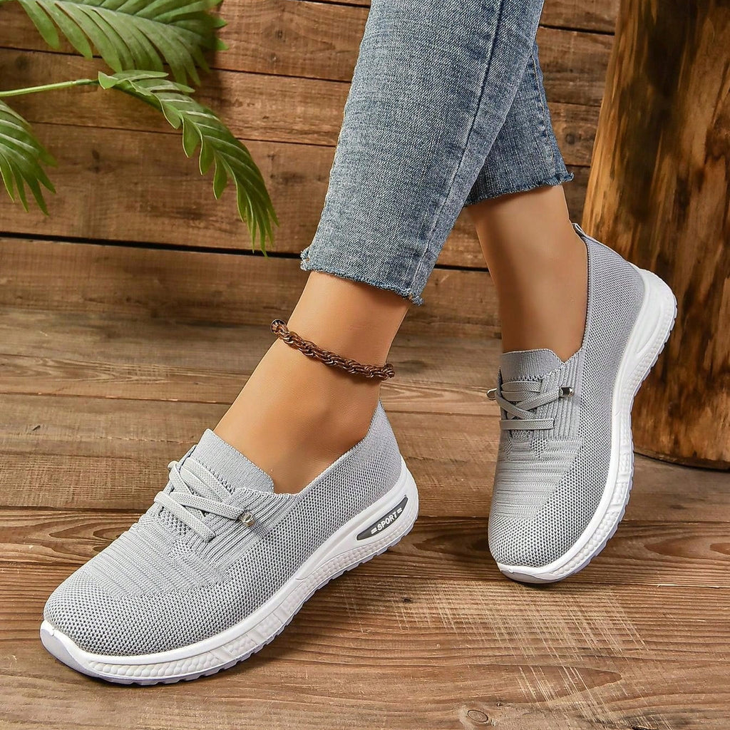 Women's light grey slip-on trainers with lace detail and white textured soles