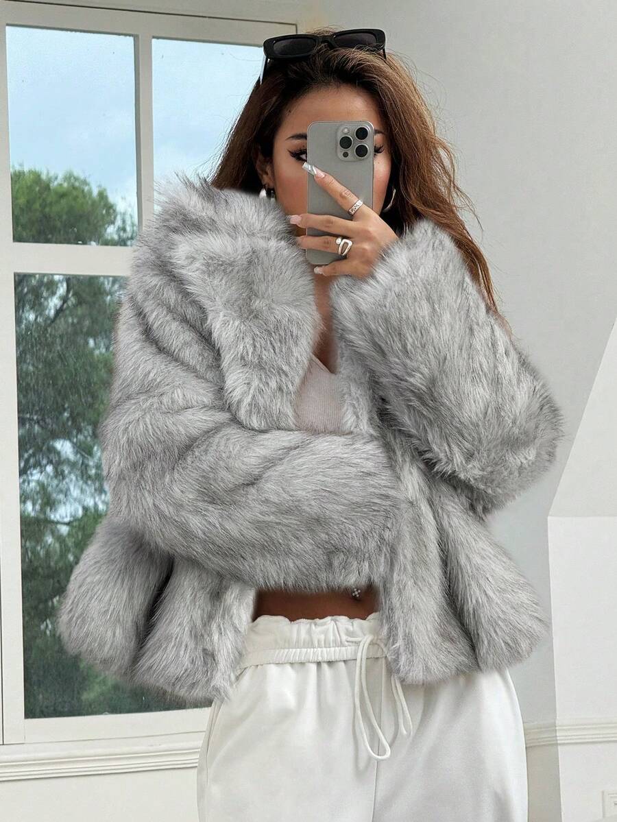 Woman wearing an open-front faux fur jacket with wide lapels and long sleeves