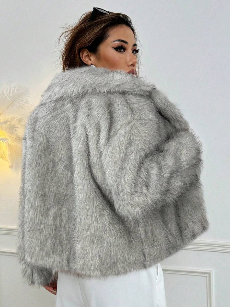 Woman wearing an open-front faux fur jacket with wide lapels and long sleeves