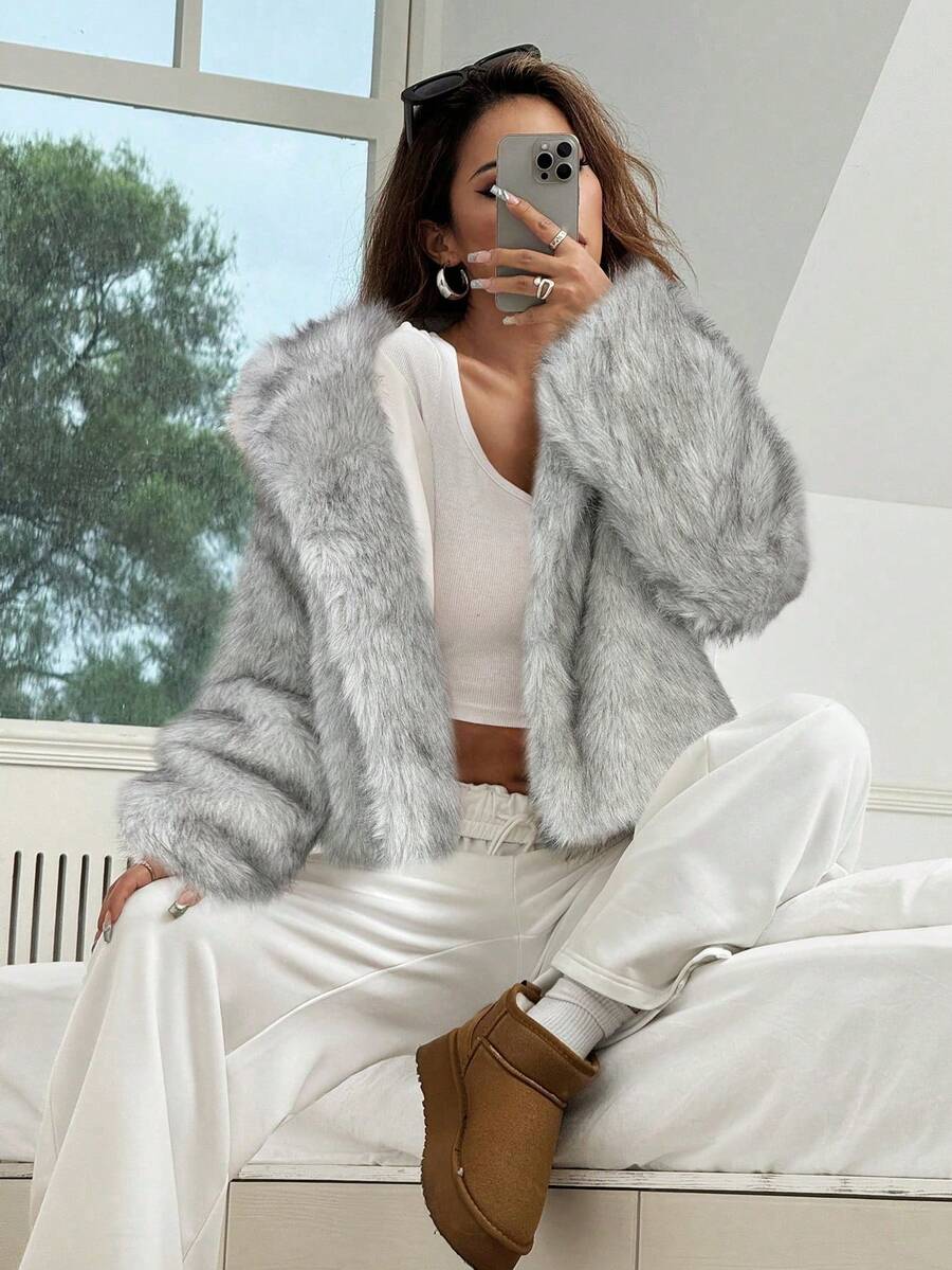 Woman wearing an open-front faux fur jacket with wide lapels and long sleeves