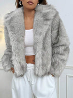 Woman wearing an open-front faux fur jacket with wide lapels and long sleeves