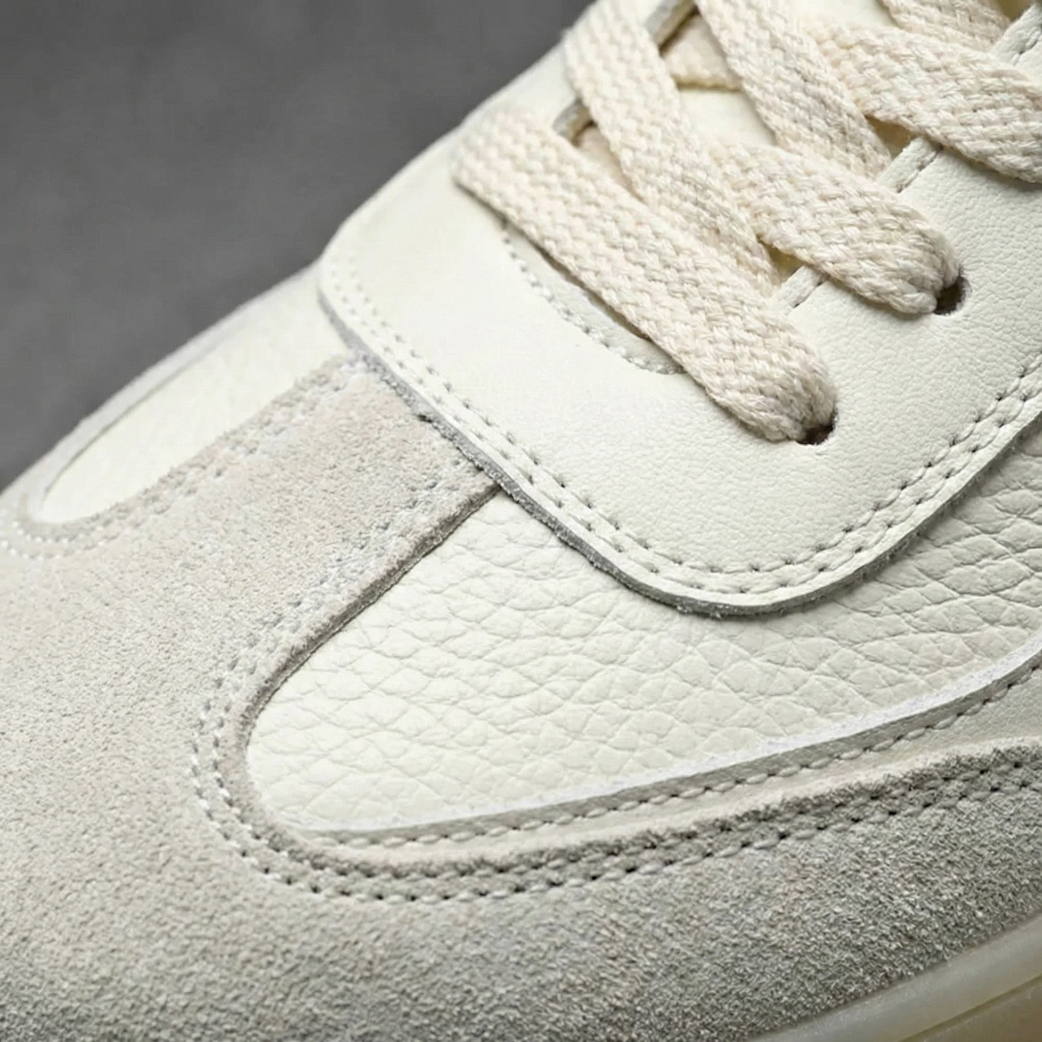 Beige men's lace-up sneakers with textured panels and gum-coloured soles