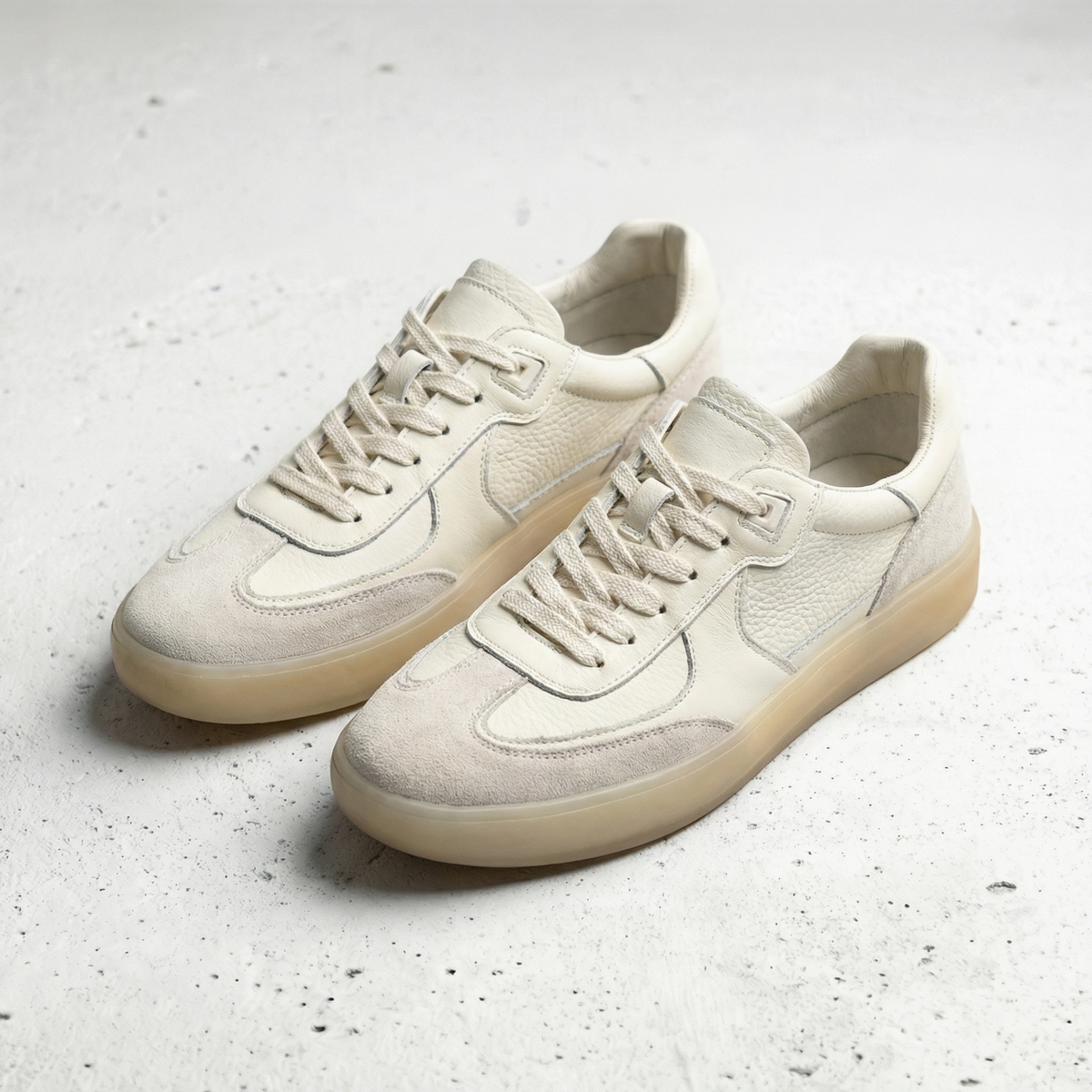 Beige men's lace-up sneakers with textured panels and gum-coloured soles