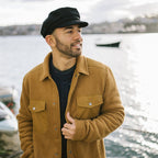 Black fiddler cap with structured crown, layered band and short brim
