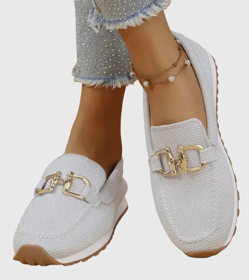 Women's textured slip-on loafers with decorative metal-tone buckles and ridged soles