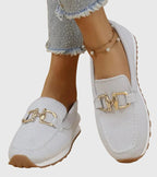 Women's textured slip-on loafers with decorative metal-tone buckles and ridged soles