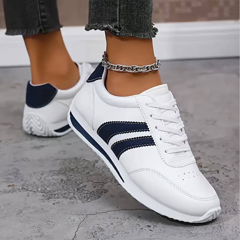 White lace-up trainers with navy side stripes and a flat sole
