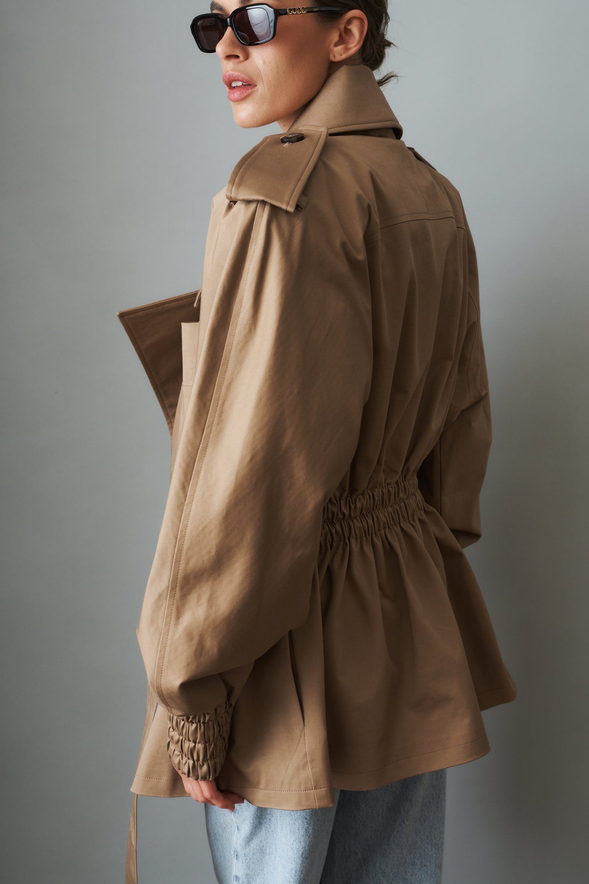 Women's beige tie-waist trench coat with wide lapels and gathered long sleeves