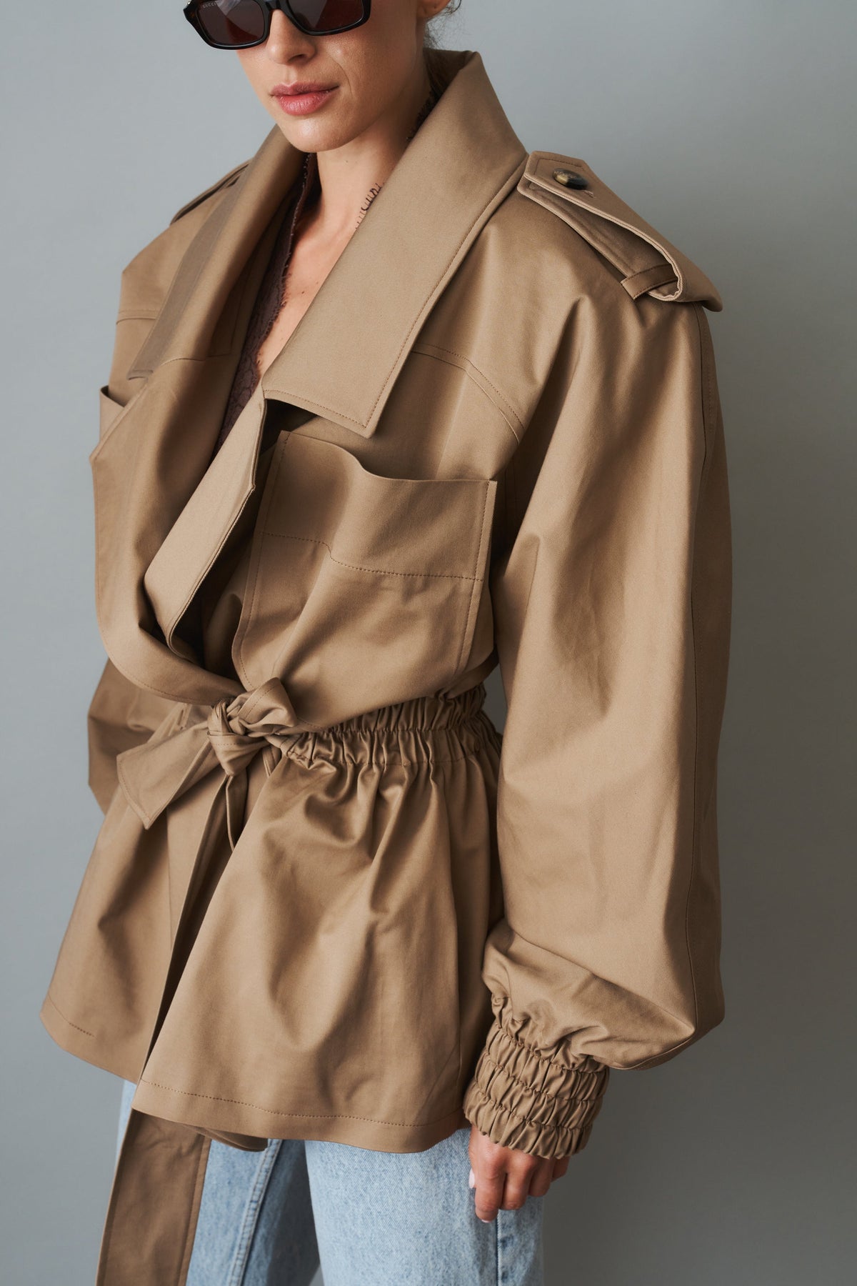 Women's beige tie-waist trench coat with wide lapels and gathered long sleeves