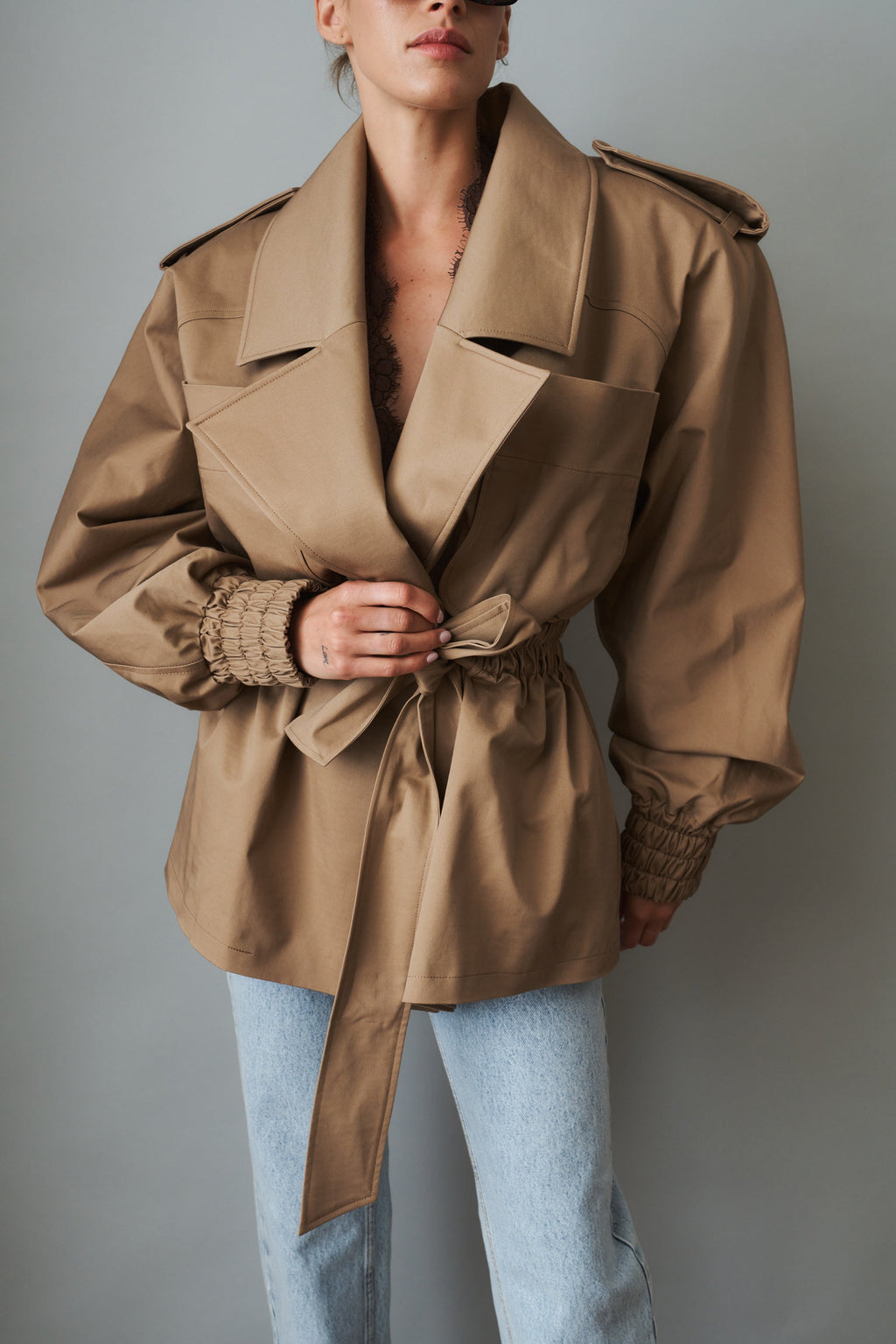 Women's beige tie-waist trench coat with wide lapels and gathered long sleeves