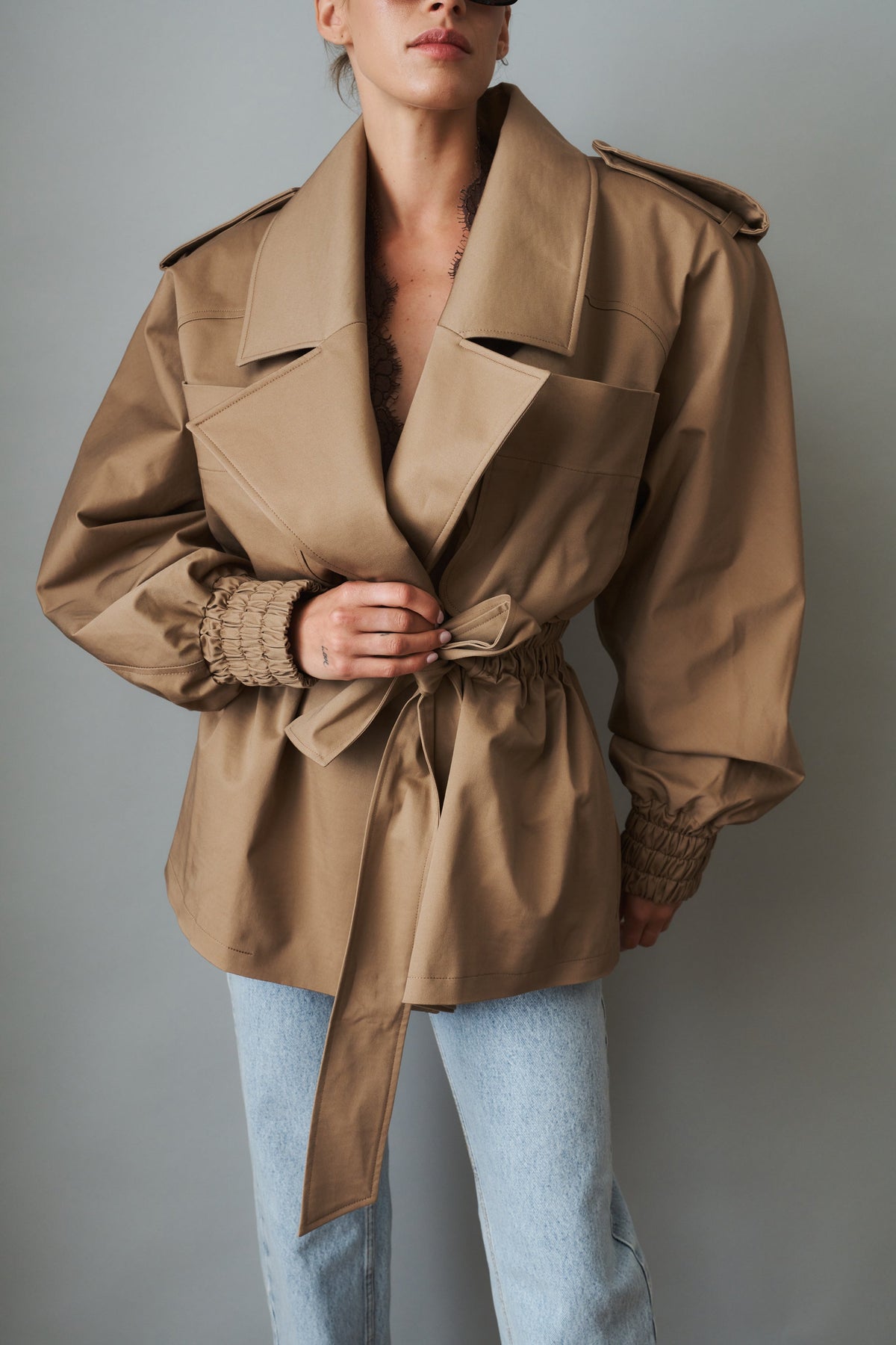 Women's beige tie-waist trench coat with wide lapels and gathered long sleeves