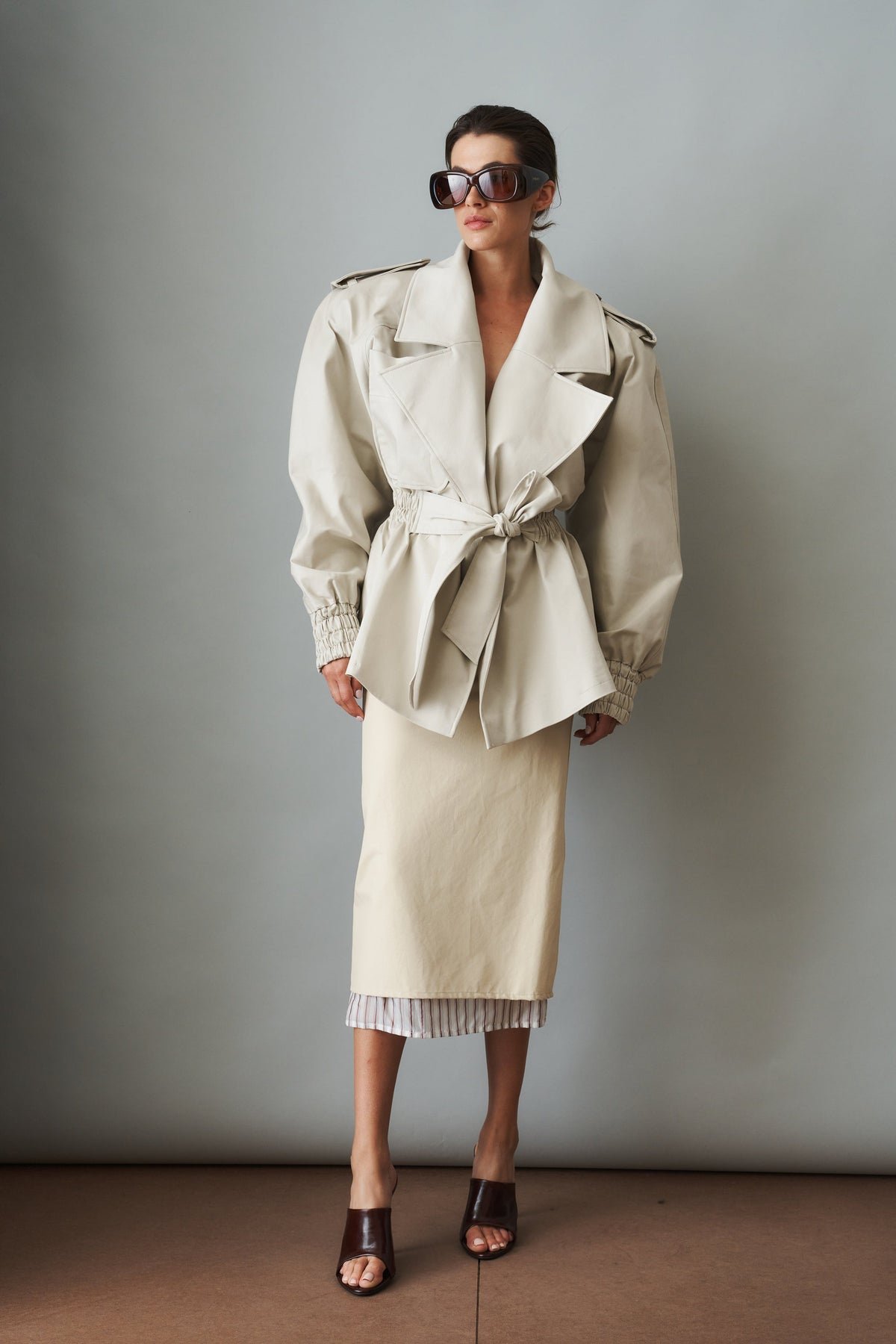 Women's cream trench coat with wide lapels, tie waist and elasticated cuffs