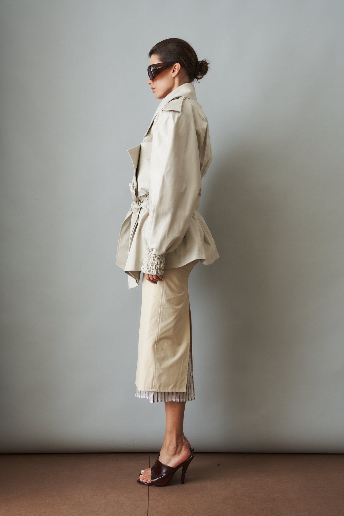 Women's cream trench coat with wide lapels, tie waist and elasticated cuffs