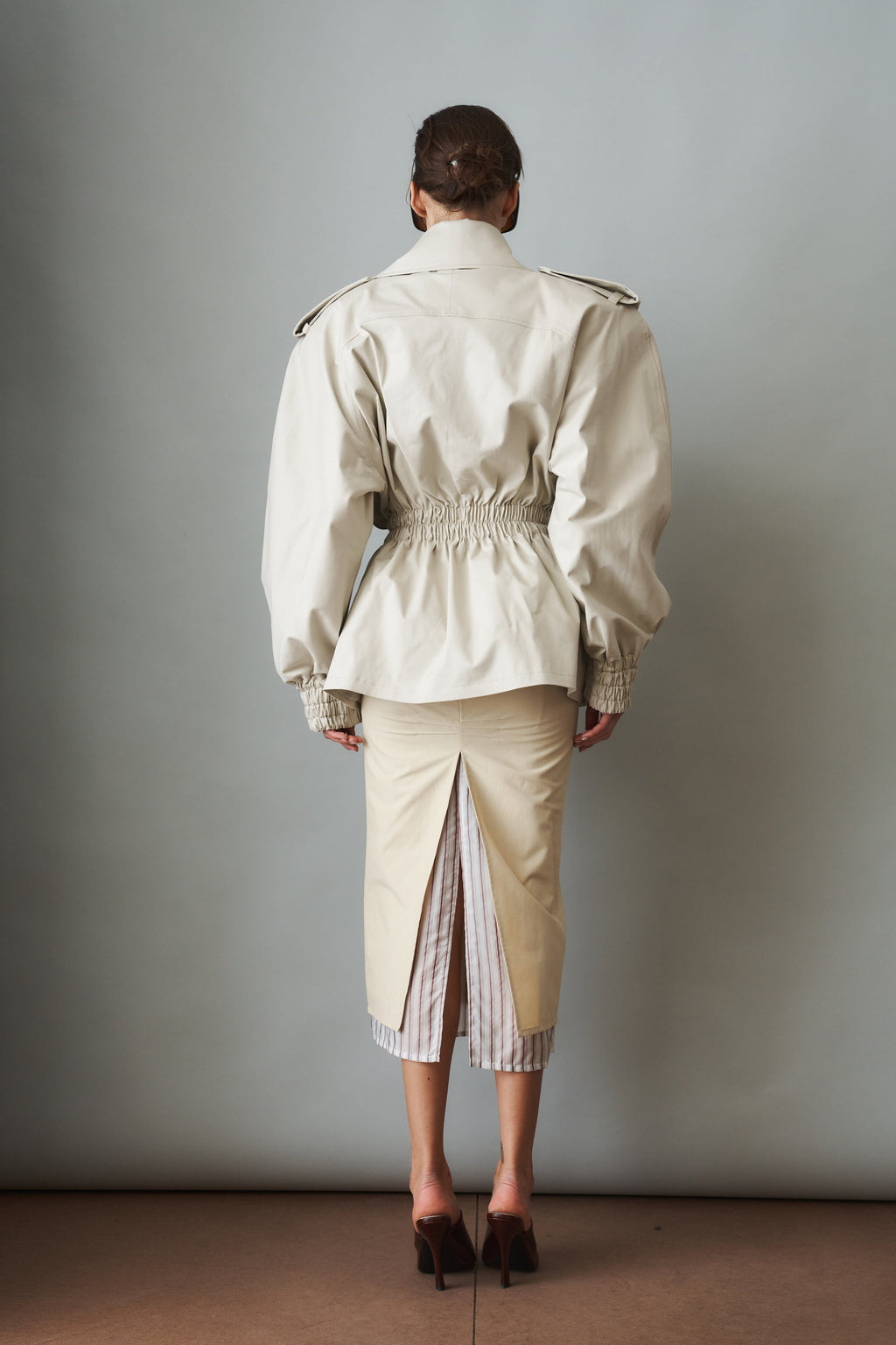 Women's cream trench coat with wide lapels, tie waist and elasticated cuffs