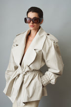 Women's cream trench coat with wide lapels, tie waist and elasticated cuffs