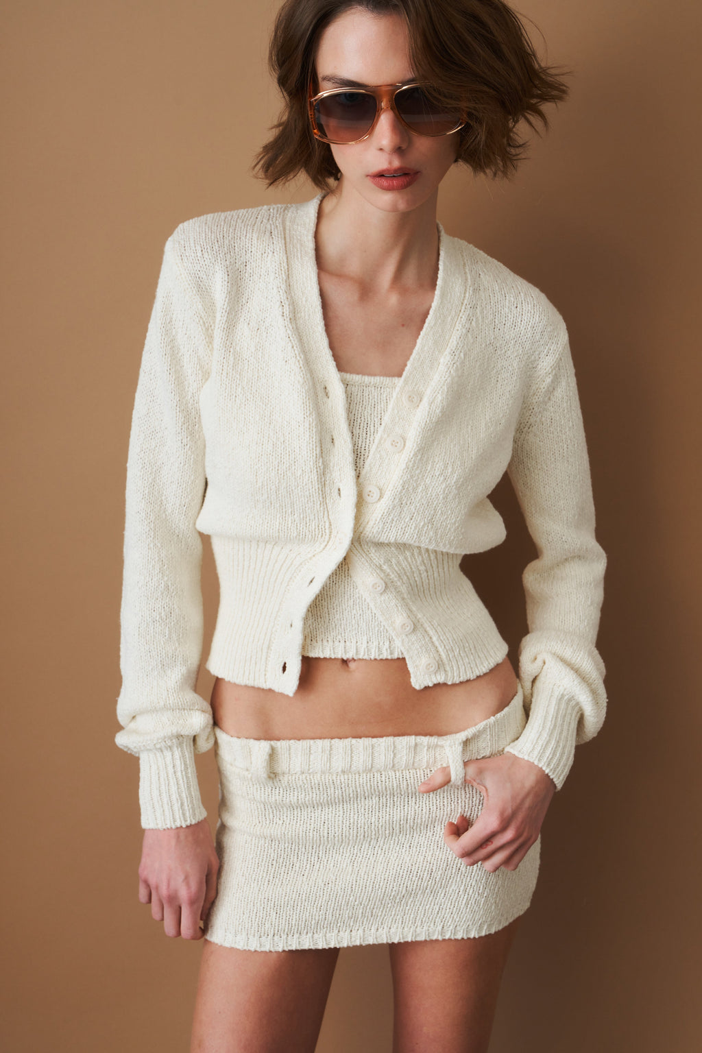 Women's cream cropped V-neck cardigan with long sleeves and button front