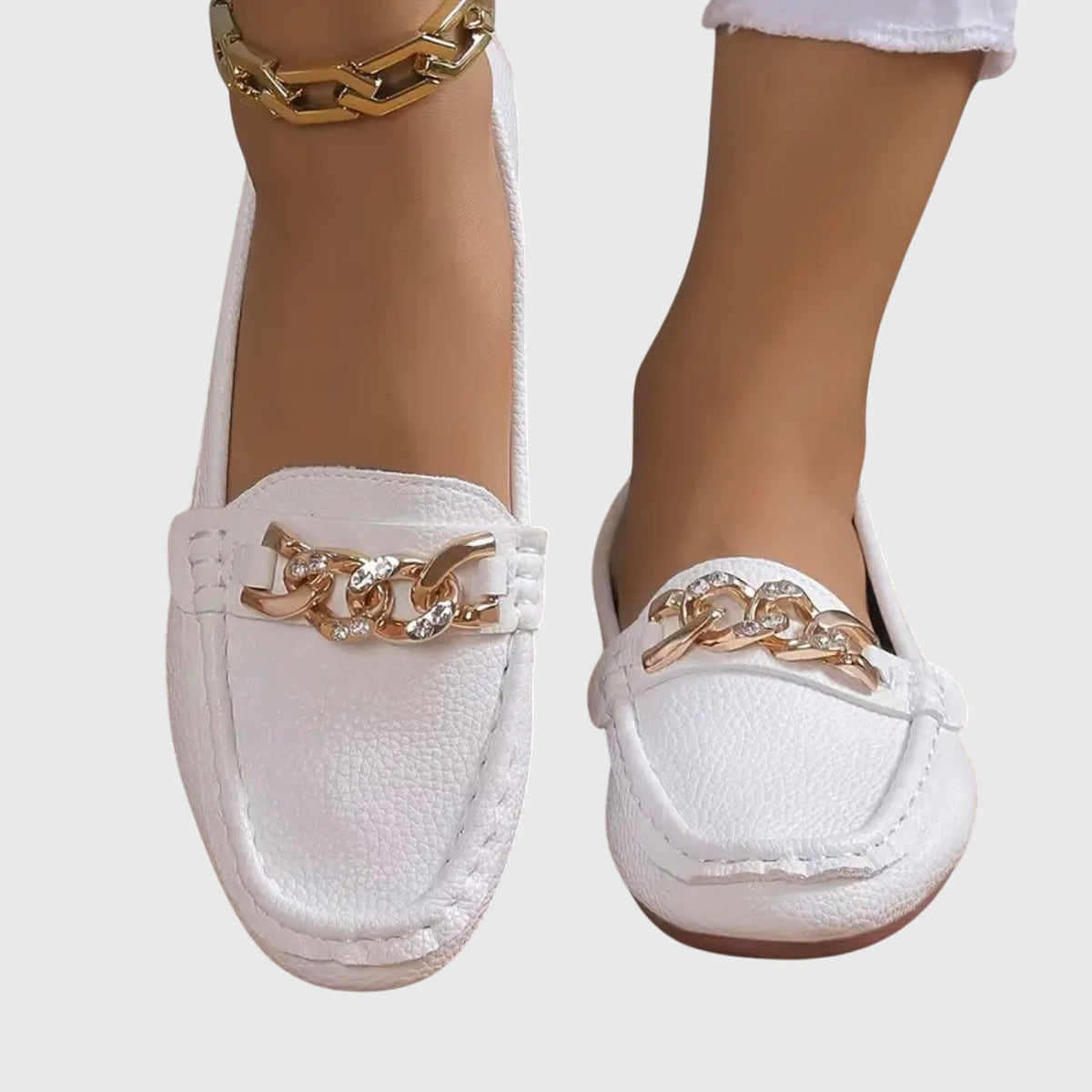 Women's flat slip-on loafers with moc toe stitching and decorative chain detail