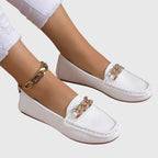 Women's flat slip-on loafers with moc toe stitching and decorative chain detail
