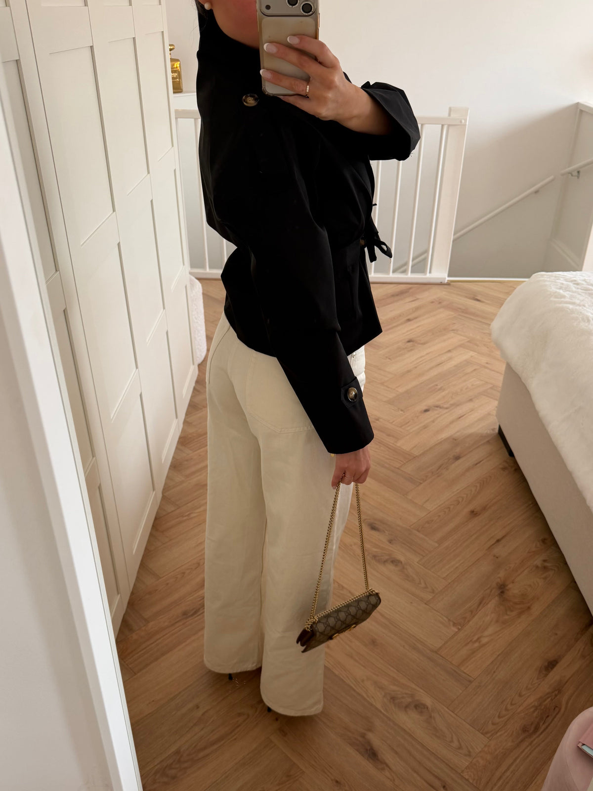 Women's black cropped trench jacket with high collar, buttons and tie belt