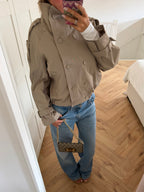 Women's beige cropped double-breasted trench jacket with long sleeves and adjustable cuffs