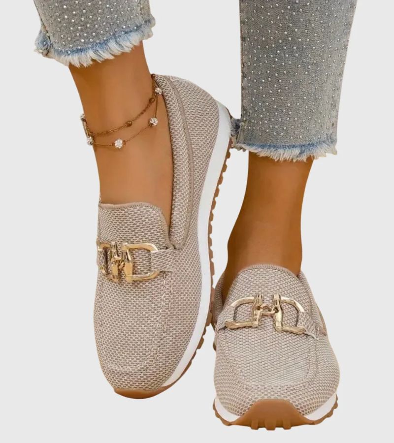 Women's textured slip-on loafers with decorative metal-tone buckles and ridged soles