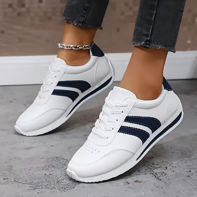 White lace-up trainers with navy side stripes and a flat sole
