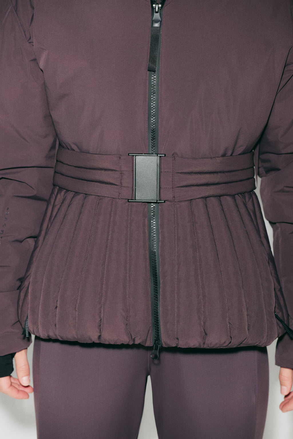 Women's hooded quilted ski jacket with belted waist and long sleeves
