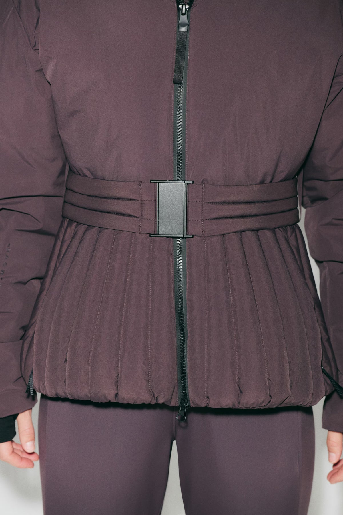 Women's hooded quilted ski jacket with belted waist and long sleeves