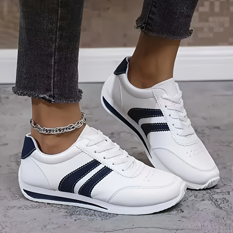 White lace-up trainers with navy side stripes and a flat sole