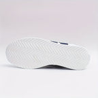 White lace-up trainers with navy side stripes and a flat sole
