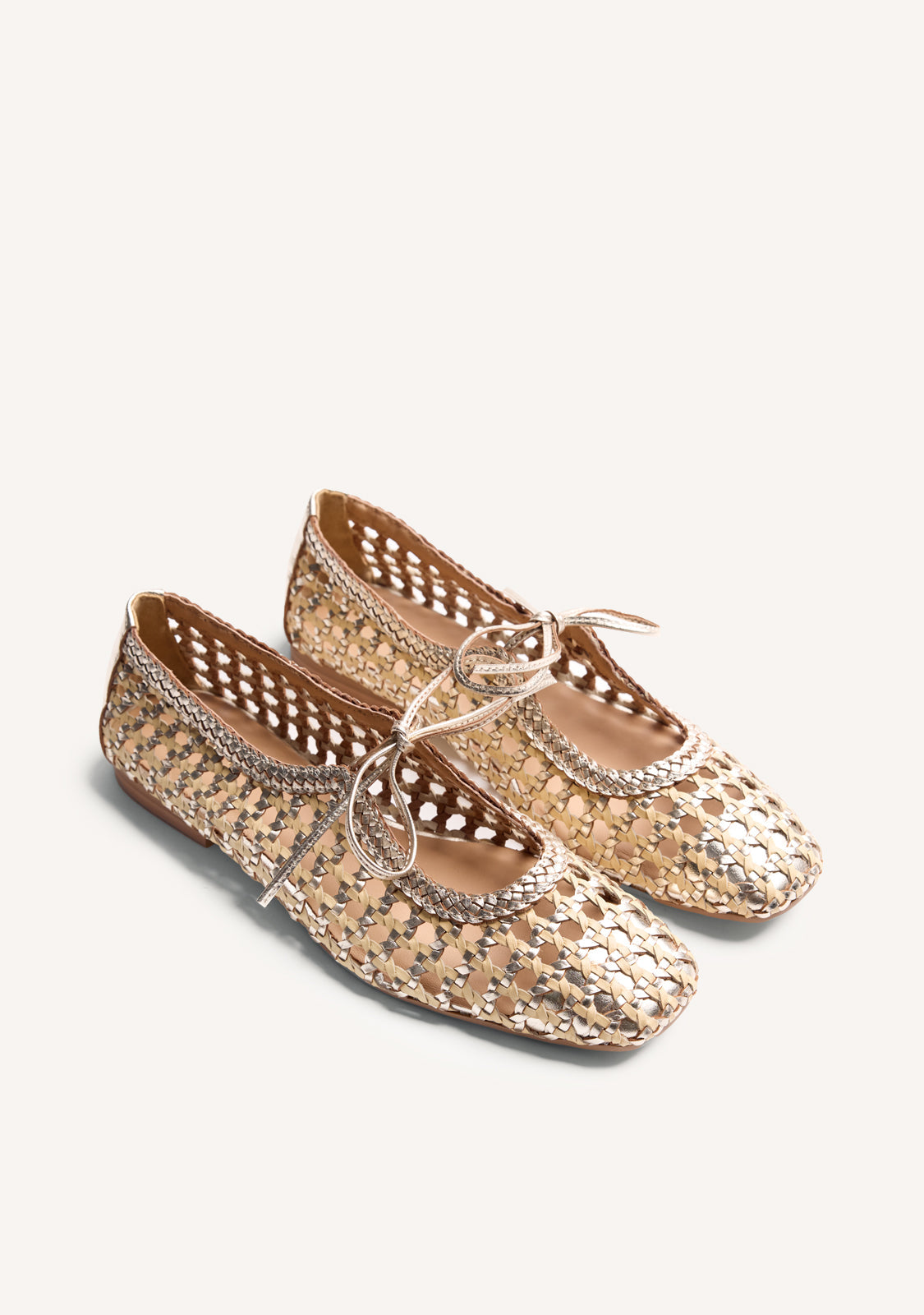 Gold woven ballet flats with ankle tie straps and low heels
