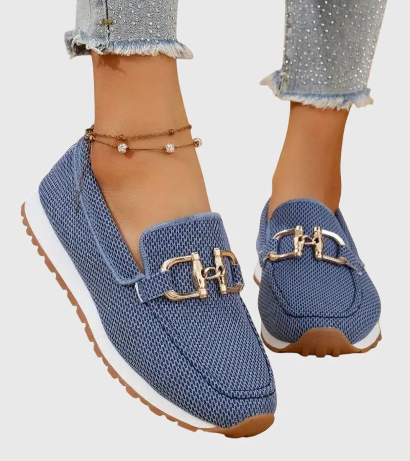 Women's textured slip-on loafers with decorative metal-tone buckles and ridged soles