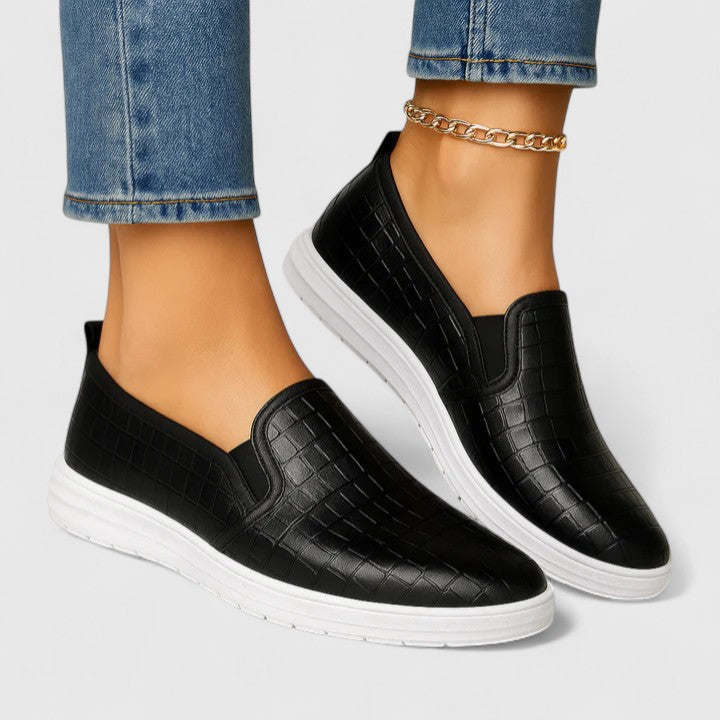 Women's black textured slip-on loafers with white flat soles