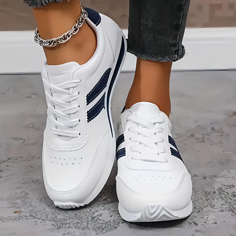 White lace-up trainers with navy side stripes and a flat sole