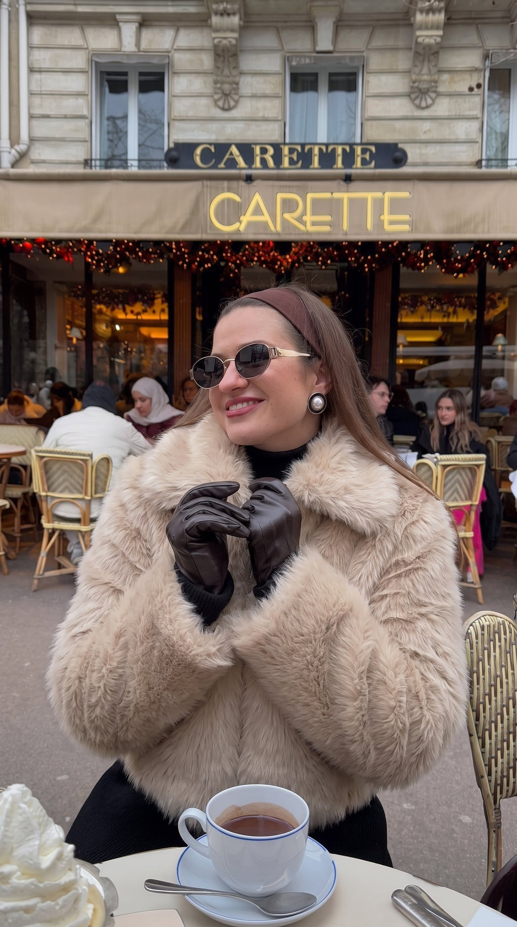 Woman wearing a beige faux fur bomber jacket with an oversized collar