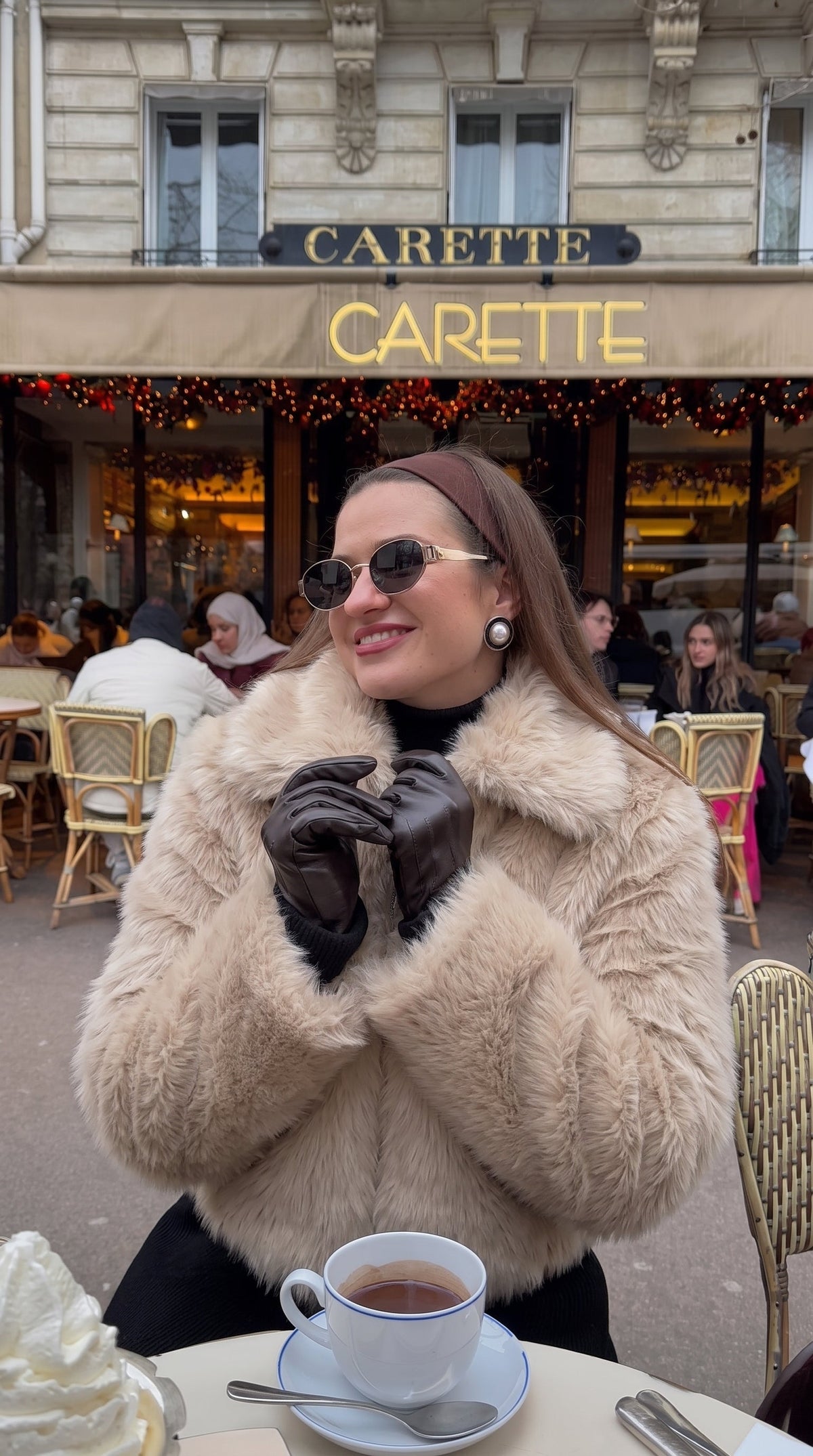 Woman wearing a beige faux fur bomber jacket with an oversized collar
