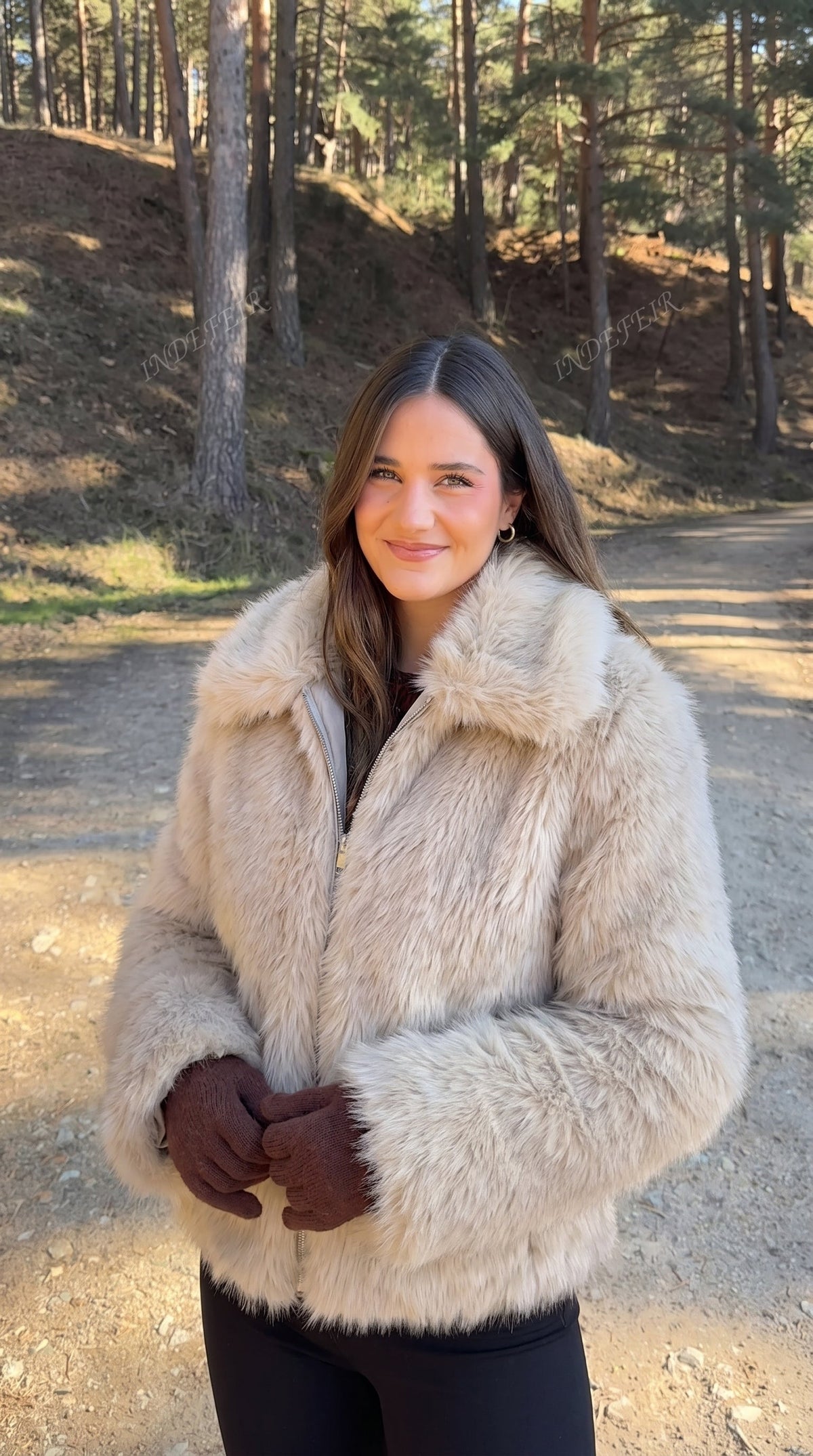Woman wearing a beige faux fur bomber jacket with an oversized collar