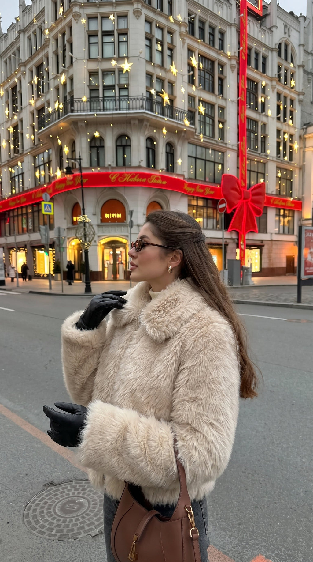 Woman wearing a beige faux fur bomber jacket with an oversized collar