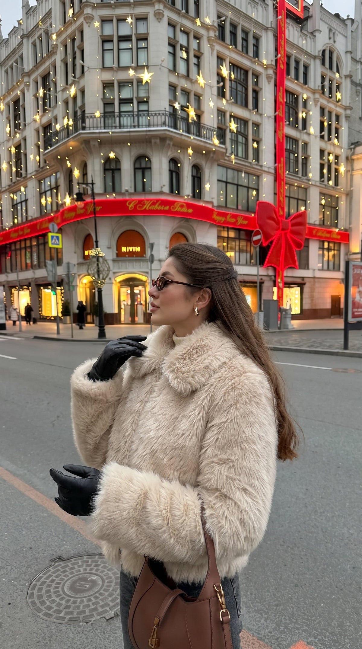 Woman wearing a beige faux fur bomber jacket with an oversized collar