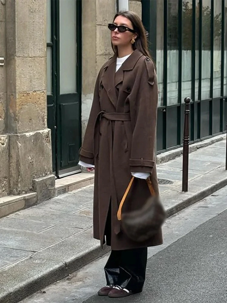 Woman wearing a long belted double-breasted trench coat