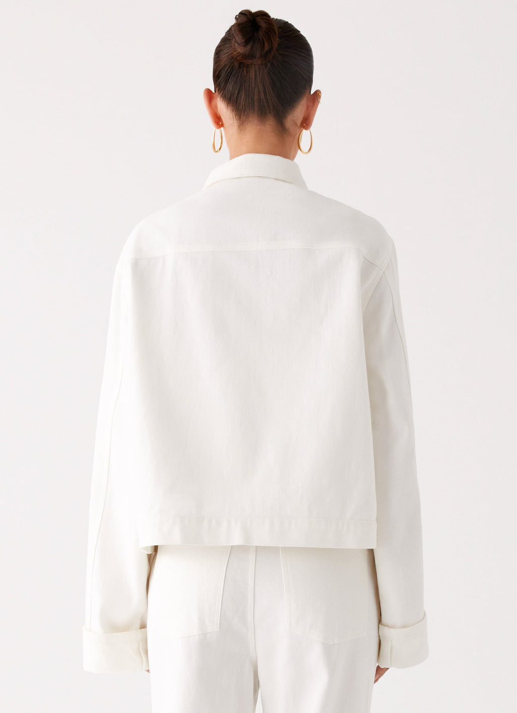 Women's oversized white denim jacket with shirt collar, chest pockets and snap fastenings