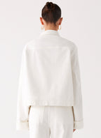 Women's oversized white denim jacket with shirt collar, chest pockets and snap fastenings